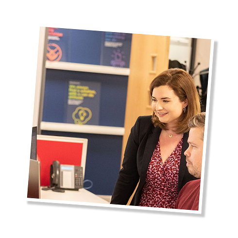 The fith image in a slide show, showing a man and a woman discussing the design of some funeral stationery
